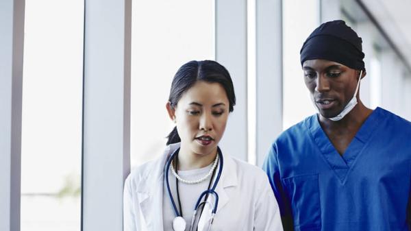 Doctor and nurse walking in hospital hallway