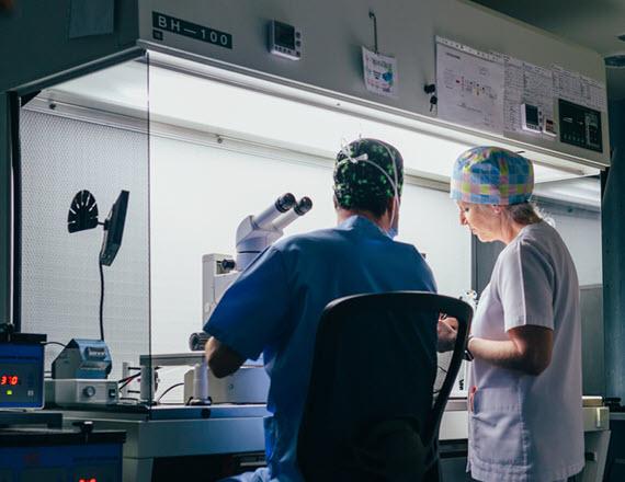 Male and female physicians collaborating in a lab Male and female physicians collaborating in a lab